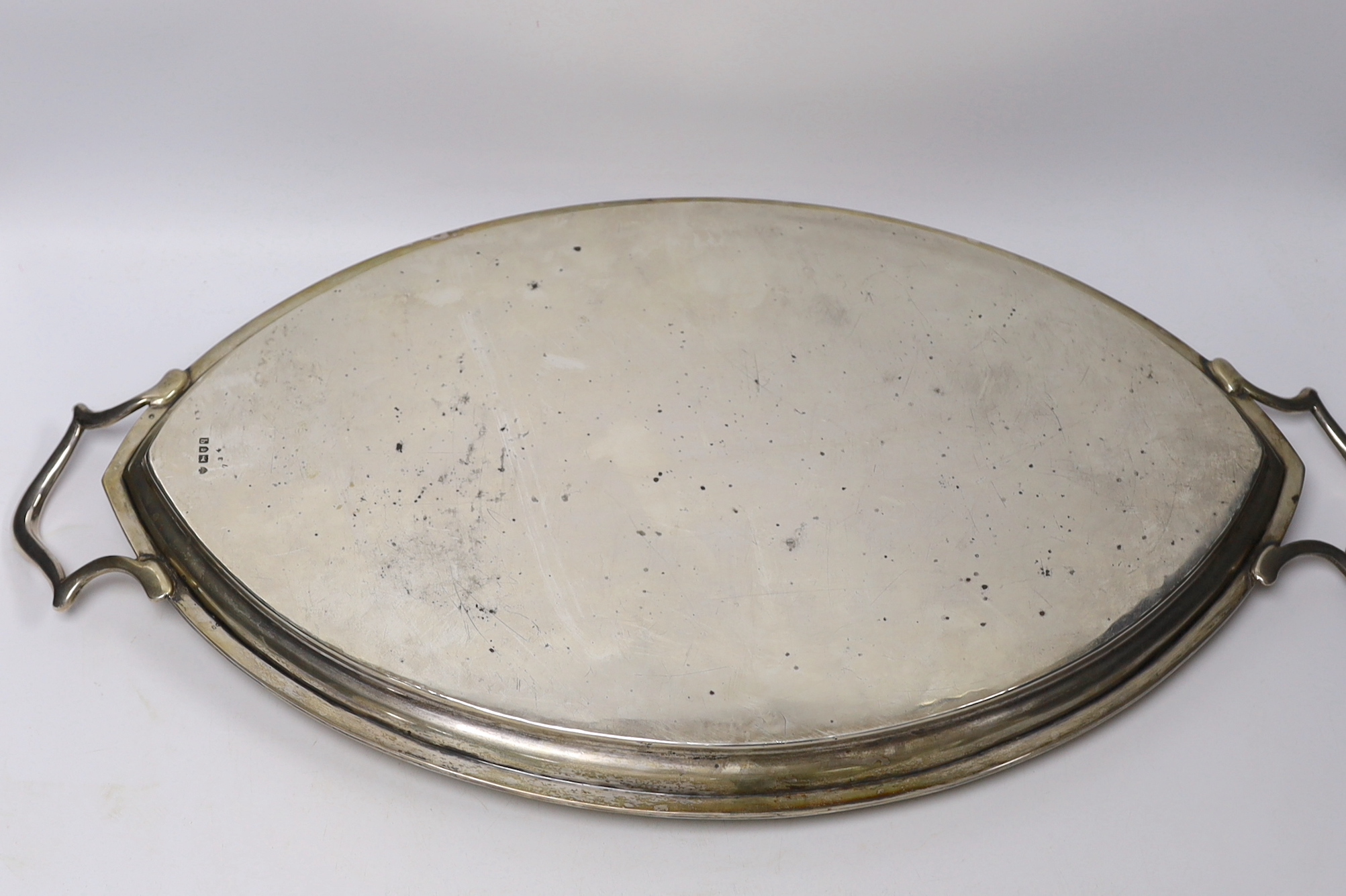 A George V silver elliptical two handled tea tray, Edward Barnard & Sons, London, 1911, 62.6cm over handles